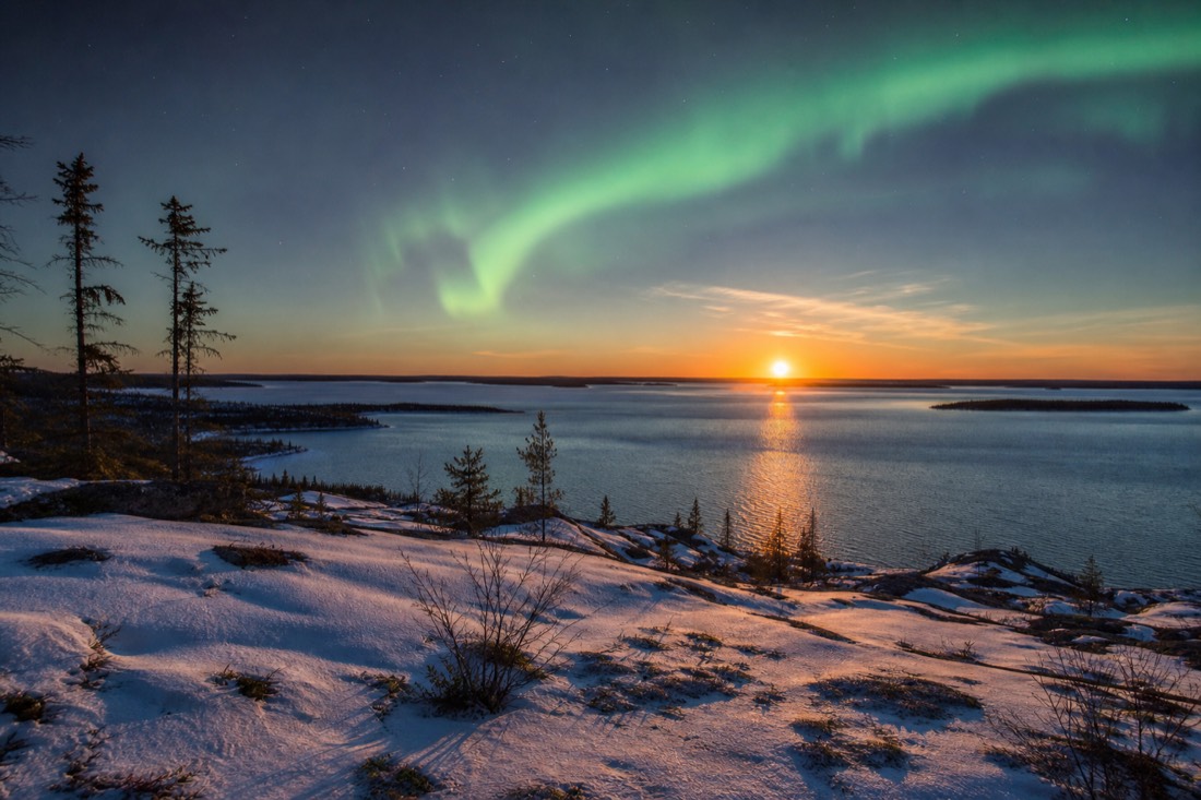 Midnight sun glowing low over Great Slave Lake in June with the sky still bright